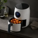 freidora de aire Taurus Respire compacta con cesta abierta y alimentos cocinados en encimera de cocina moderna