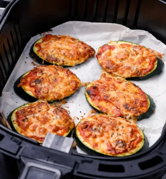 Rodajas de calabacín con tomate y queso gratinadas en freidora de aire listas para servir
