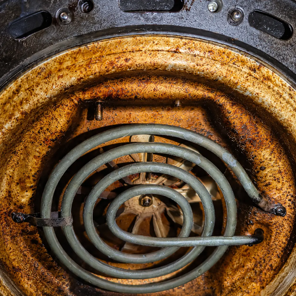 Resistencia interior de una airfryer con restos que pueden provocar humo
